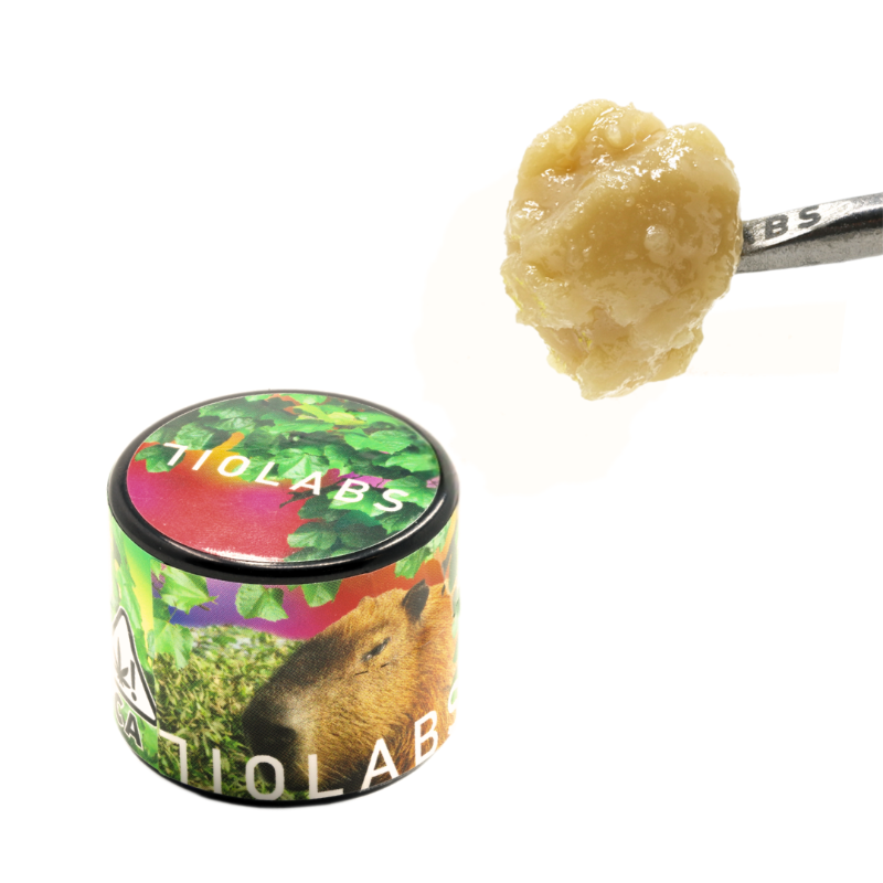 Tio Labs container with a spoonful of brown substance on a white background