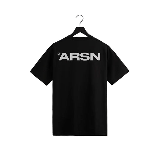 Black ARSN t-shirt featuring bold white ARSN logo on the back, minimalist streetwear tee hanging on black hanger against light gray wall.